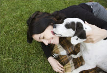 happy-girl-fun-loves-black-white-dog-on-grass-oudoors